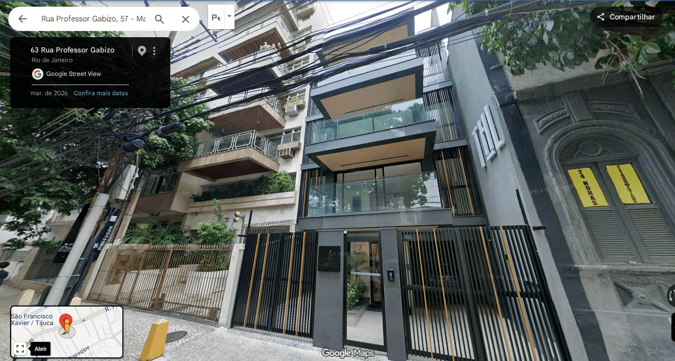 Fachada frontal do edifício moderno com detalhes em metal preto e varandas com piso amadeirado.